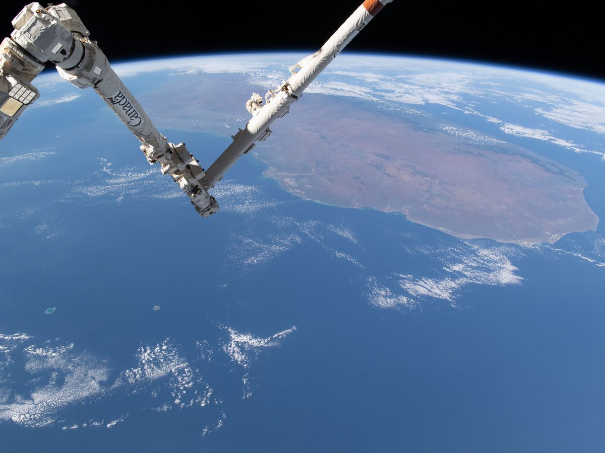 A robotic arm on the International Space Station above Earth